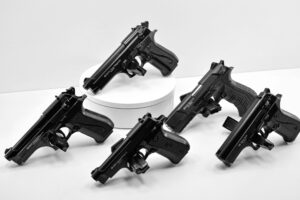 A collection of various handguns arranged on a white background for display purposes.